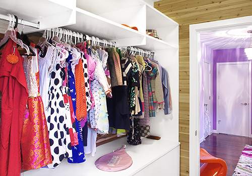 Girl's White Walk-In Closet with Continuous Hanging Space and Open Shelves