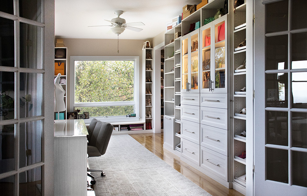 Luxury Walk-In Closet with Shoe Cabinets and Purse Storage Behind Glass Doors with LED Lighting