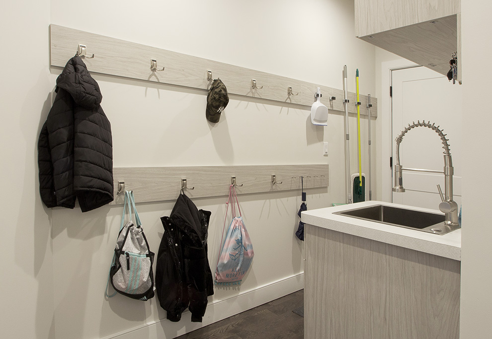 Mudroom Hooks Organize an Expansive Wall for Mops, Coats, Back Packs