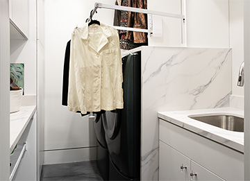 White Laundry Room with High Ceilings and Pull-Down Clothes Rod